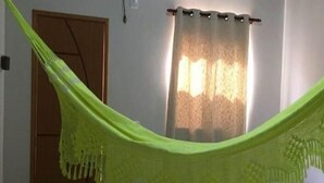 Una habitación con cama, hamaca, puerta y aire acondicionado.