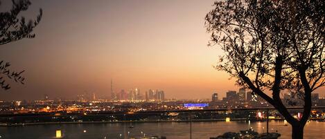 A table set for dining with a city skyline and river in the background.