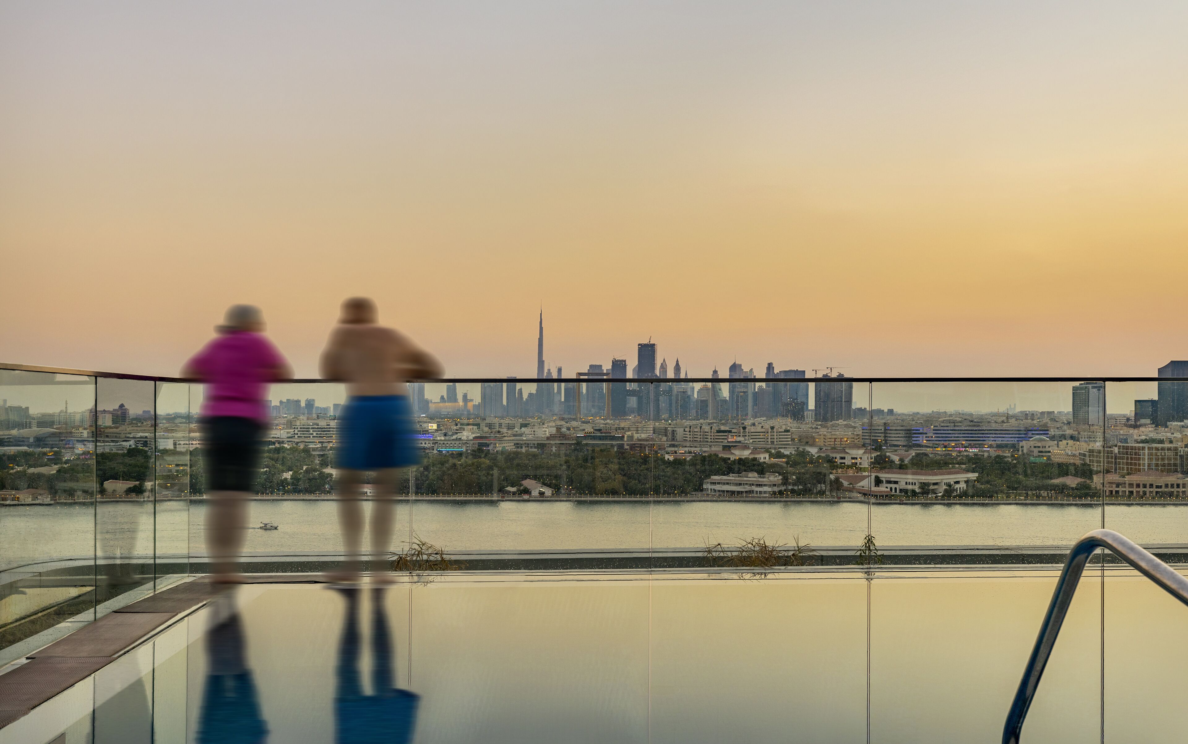 Une vue depuis le balcon d’un immeuble de grande hauteur, donnant sur un paysage urbain avec un gratte-ciel particulièrement imposant.