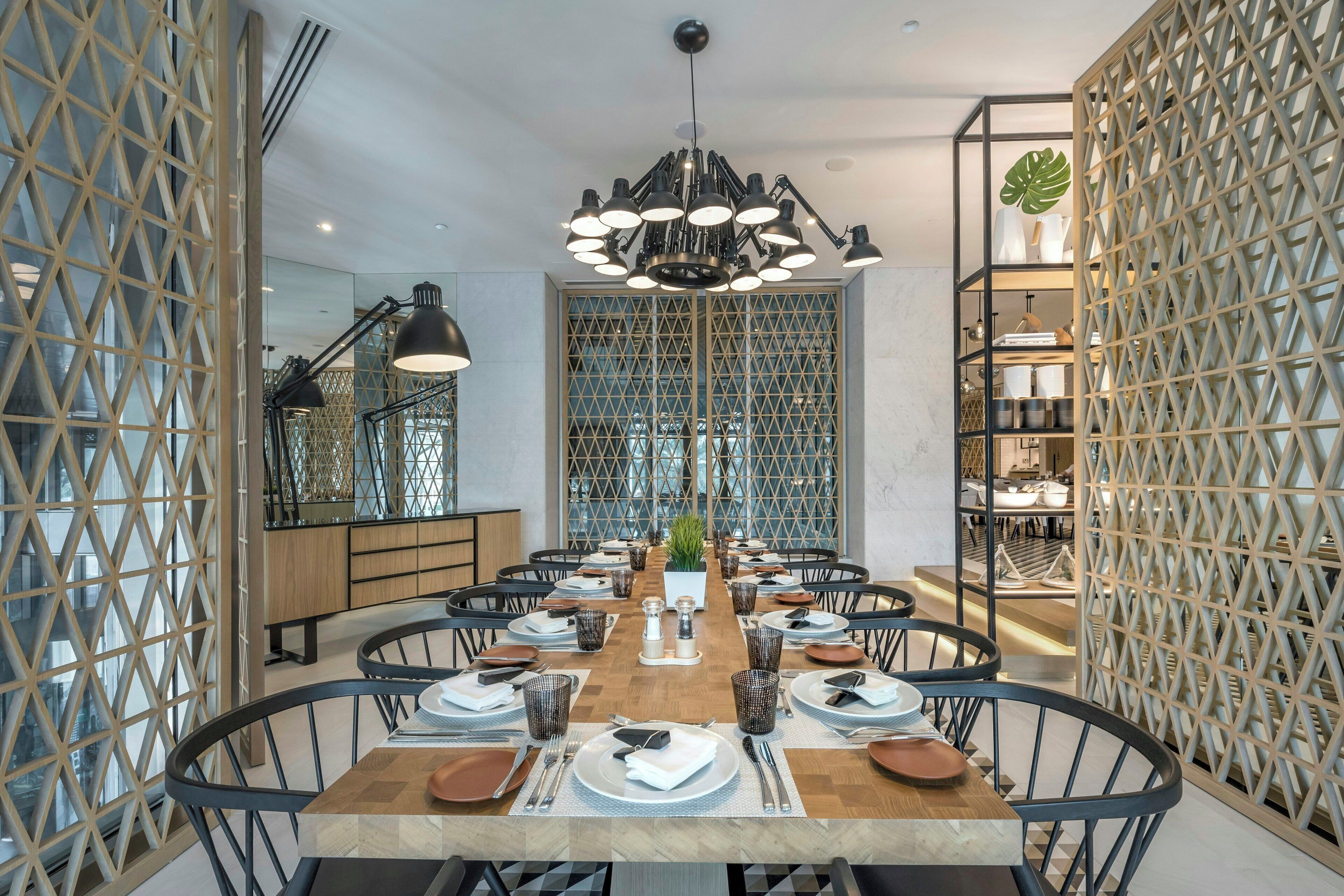 Un comedor con una mesa larga, sillas y una lámpara moderna.