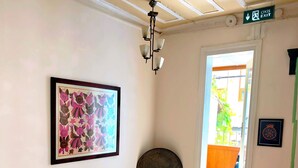 Un escalier avec des rampes vertes, une œuvre d’art encadrée au mur et une porte donnant sur l’extérieur.