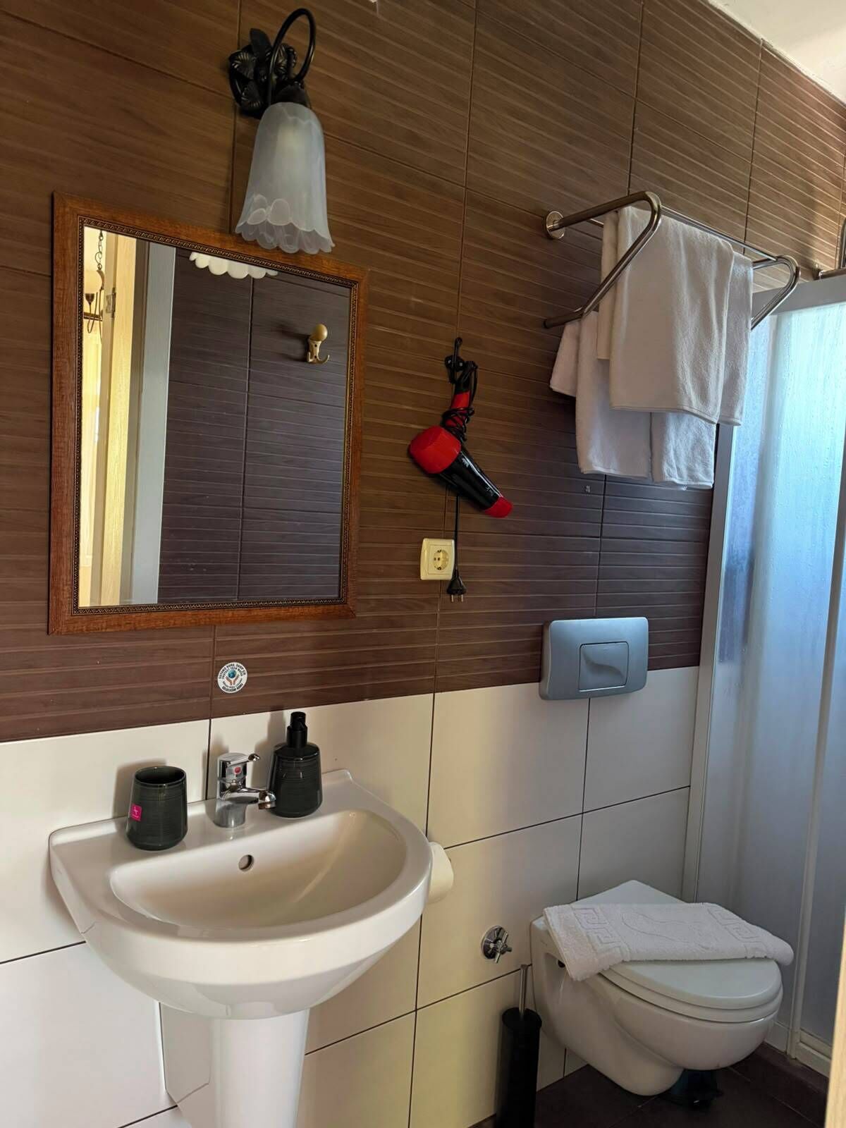 A bathroom with a sink, mirror, towel rack, and toilet.