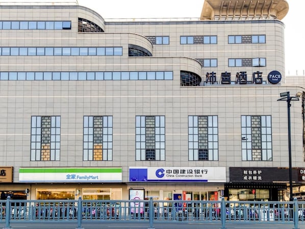 A hotel with a modern architectural design, featuring a curved facade and multiple windows.