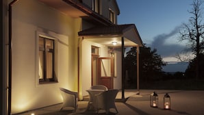A house with a porch, two wicker chairs, and two lanterns. - Willa w Dolinie (Tarnow)