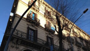 A multi-story building with ornate architectural details, including arched windows and decorative stonework. - Pensión Ciudadela (Barcelona)