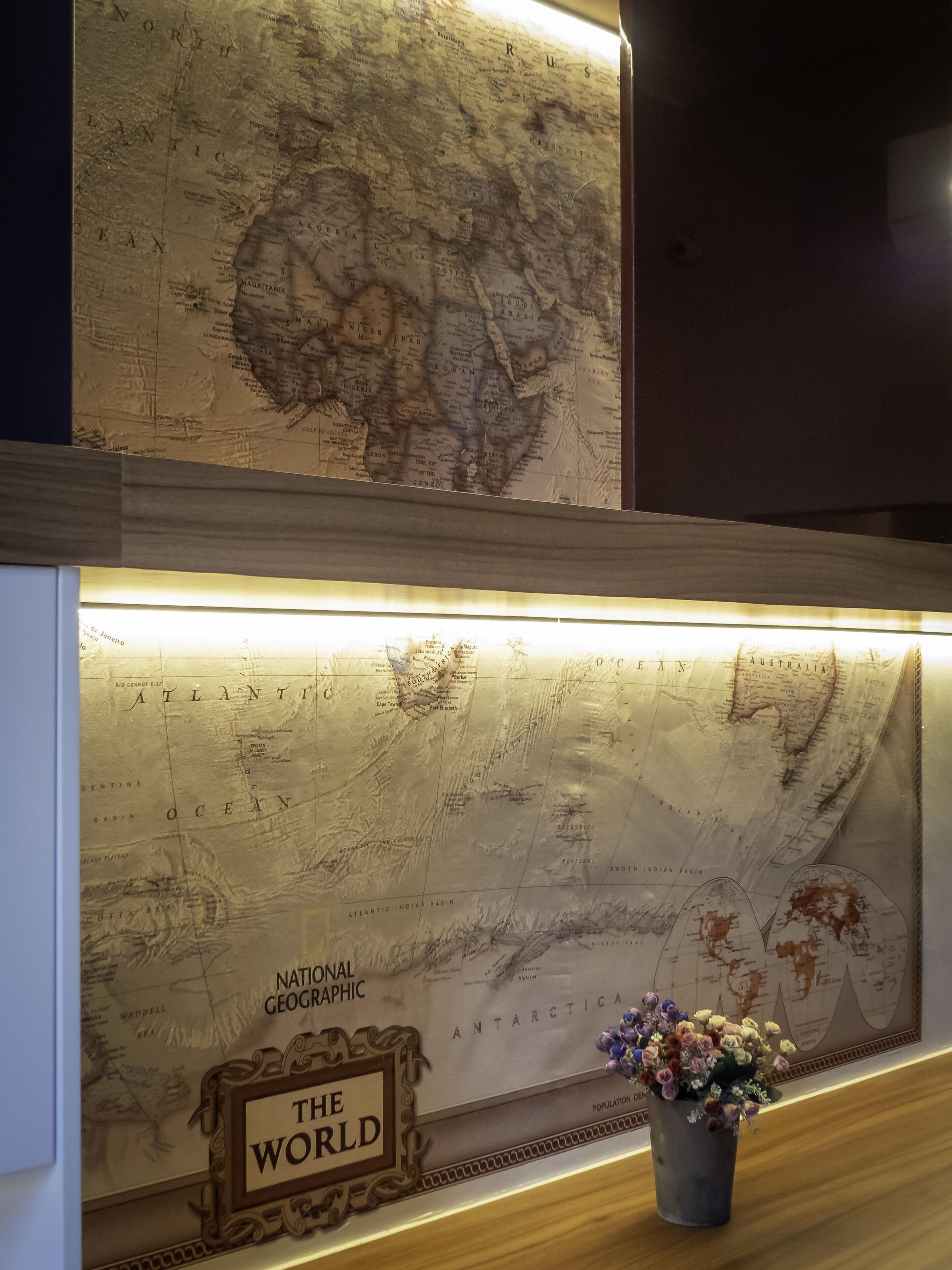 Een aan de muur bevestigde kaart met een bordje waarop 'The World' staat.