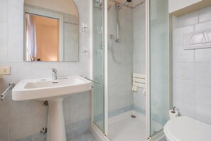 A bathroom with a white sink, a glass shower enclosure, and a toilet. - Residenza Novecento (Verona)