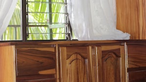 Una habitación con paneles de madera y una ventana con barrotes.