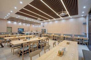 A spacious dining area with multiple wooden tables and chairs, a modern ceiling design, and a neutral color palette. - Yafeng Hotel (Huizhou West Lake) (Huizhou)