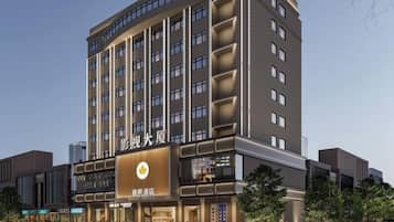 Un hotel de varios pisos con un letrero llamativo, amplias ventanas y una fachada moderna.