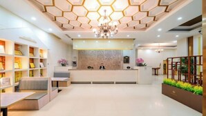 A modern hotel lobby with a reception desk, seating areas, and a decorative ceiling. - Yafeng Hotel (Huizhou West Lake) (Huizhou)
