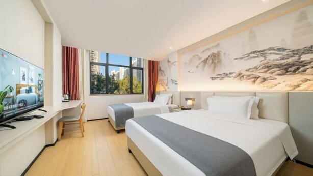 A hotel room with two beds, a desk with a TV, a painting on the wall, and a window with curtains. - Yafeng Hotel (Huizhou West Lake) (Huizhou)