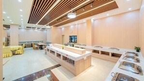 A modern hotel lobby with a central reception desk, seating area, and buffet setup. - Yafeng Hotel (Huizhou West Lake) (Huizhou)