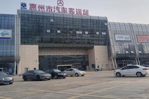 A modern building with a large parking lot in front. - Yafeng Hotel (Huizhou West Lake) (Huizhou)