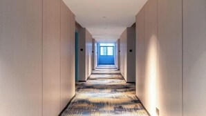 A long, narrow hallway with a patterned carpet and light-colored walls. - Yafeng Hotel (Huizhou West Lake) (Huizhou)