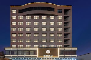 A multi-story hotel with a modern design, featuring a prominent entrance with a large illuminated sign. - Yafeng Hotel (Huizhou West Lake) (Huizhou)