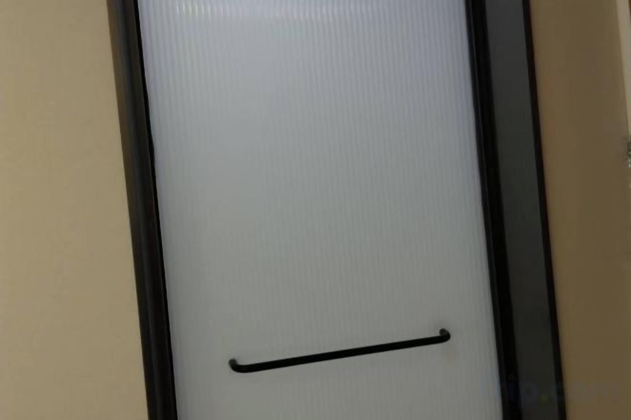 A door with a black handle and a textured surface.