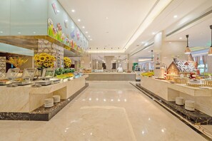A hotel lobby with a central reception desk, buffet area, and a decorative wall with floral patterns. - Welkin Hotel (Lishui)