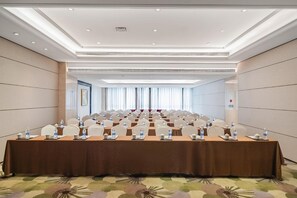 A conference room with a long table, chairs, water bottles, and teapots. - Welkin Hotel (Lishui)