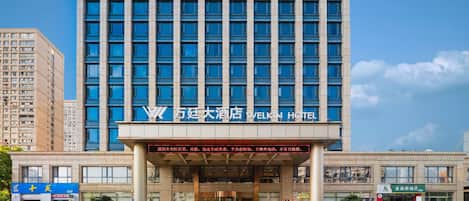 A hotel with a modern facade, multiple floors, and a prominent entrance.