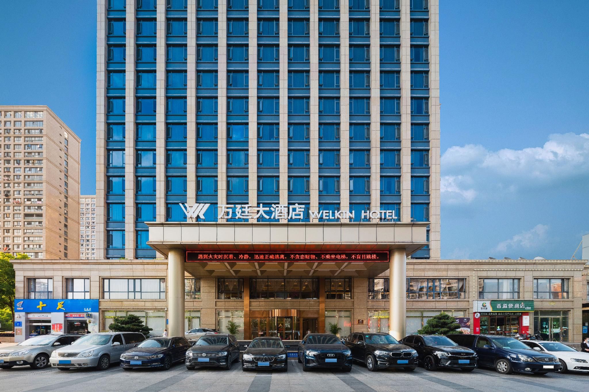 Un hotel con fachada moderna, varios pisos y una entrada destacada.