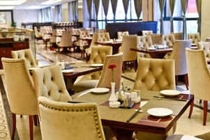 Un restaurante con varias mesas y sillas, algunas con centros de mesa florales.
