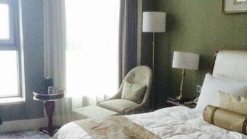 Una habitación de hotel con cama, una silla, una lámpara y una ventana.