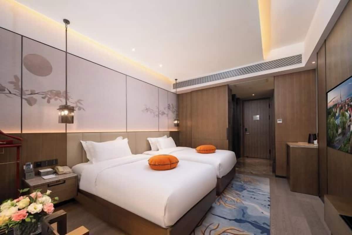 Une chambre d’hôtel avec un grand lit, un bureau, un téléphone et une télévision.