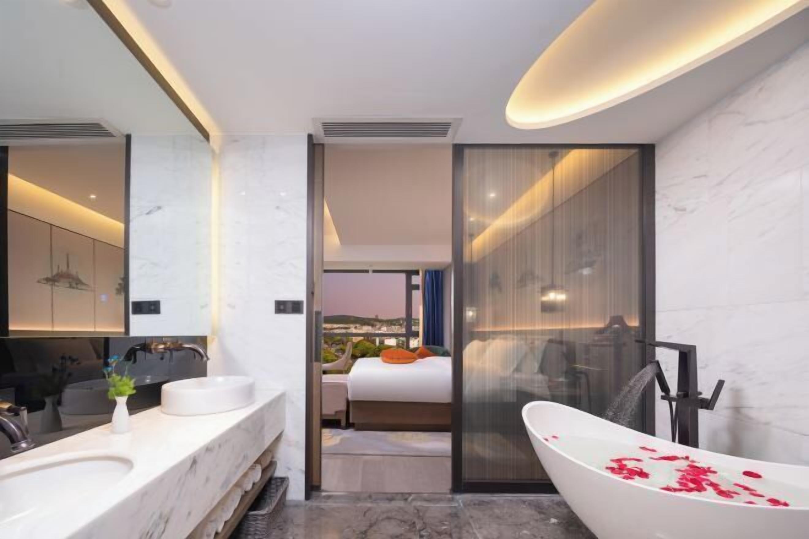 A modern bathroom with a large bathtub, a double sink vanity, and a glass shower enclosure.