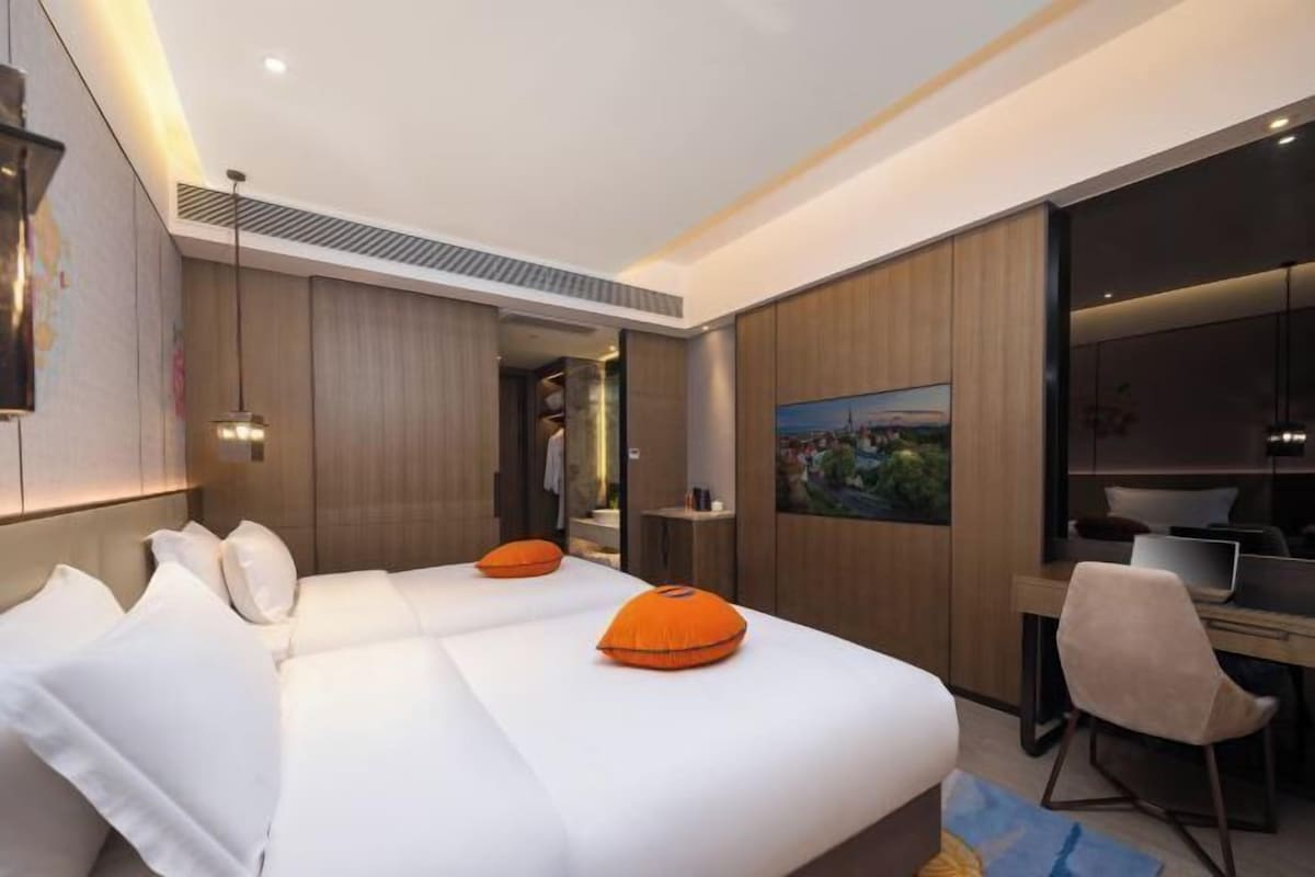 Una habitación de hotel moderna con una cama, un escritorio y una silla.