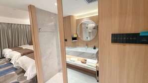 A hotel room with a bed, a bathroom with a mirror, and a control panel. - Zhong Huang Hotel (Kunming)