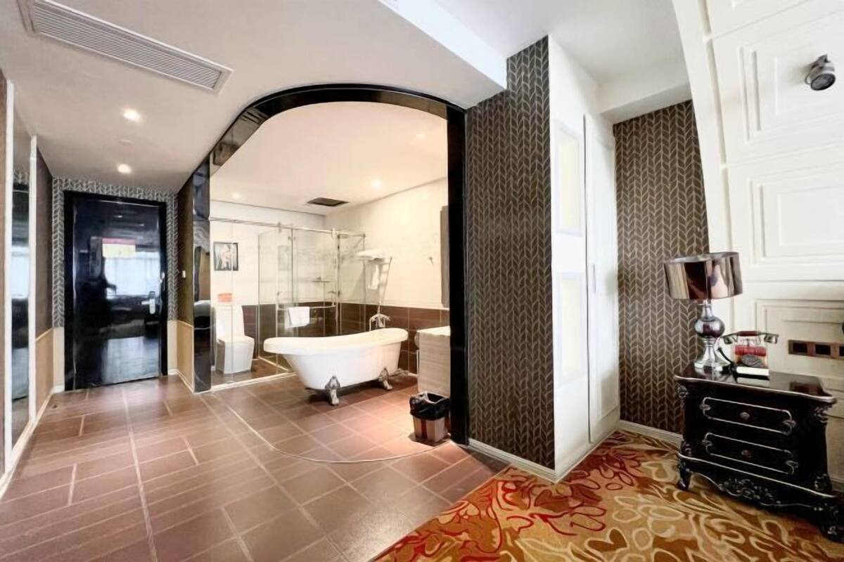 A modern bathroom with a freestanding bathtub, a mirror, and a shower area.
