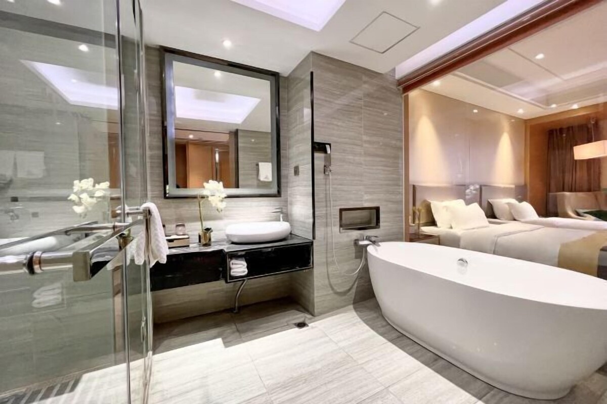 A modern bathroom with a freestanding bathtub, a glass shower enclosure, and a large mirror.
