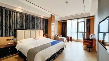 Una habitación de hotel moderna con una cama grande, un escritorio y vistas a la ciudad.