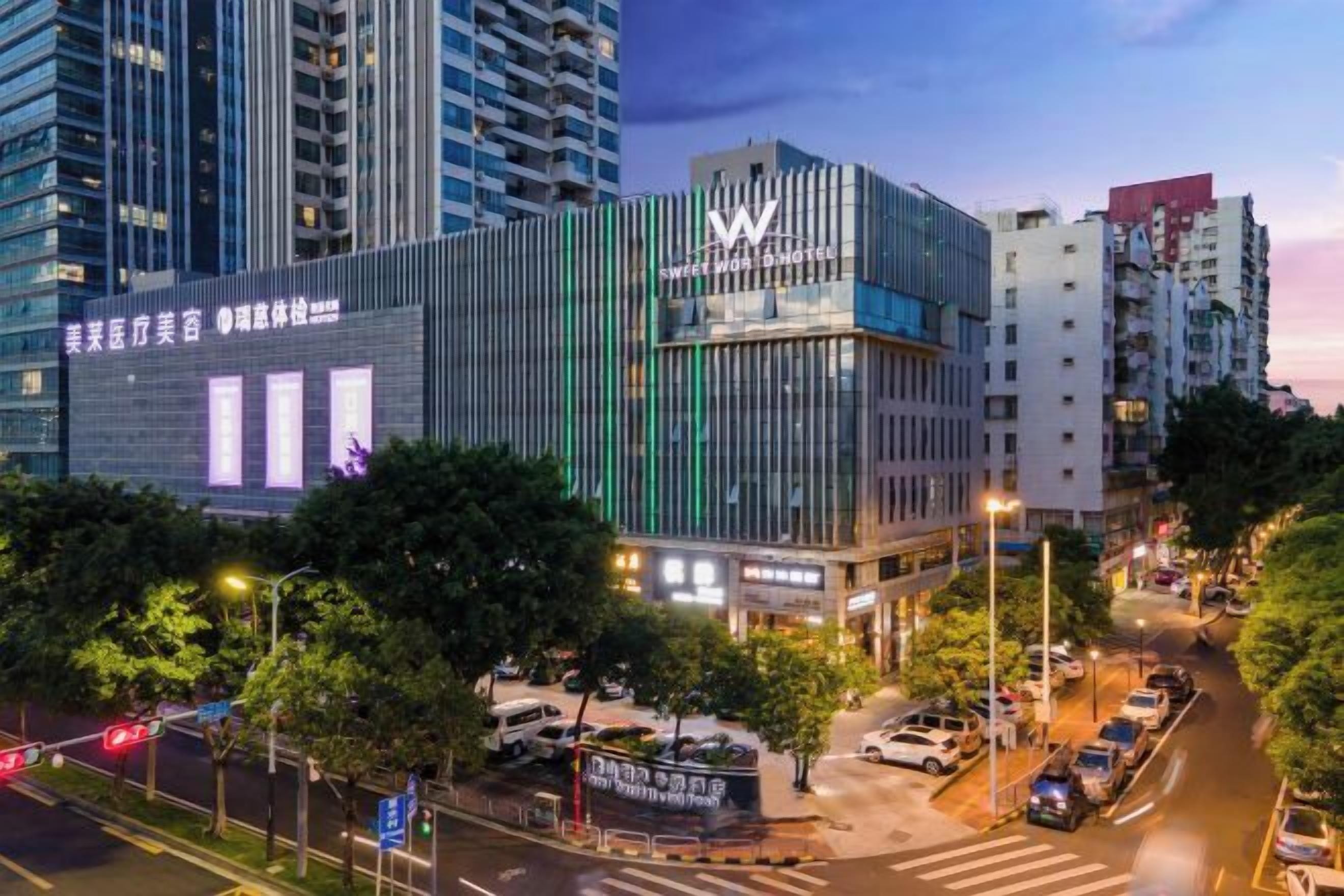A modern hotel with a prominent 'W' logo, surrounded by urban buildings and a busy street.