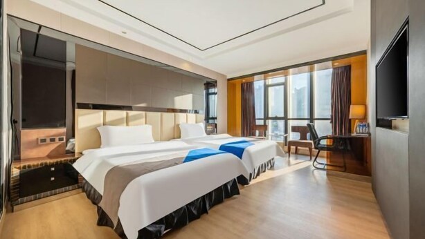 A modern hotel room with two beds, a desk, and a TV. - Sweet World Hotel (Foshan Jihuayuan, Zumiao) (Foshan)