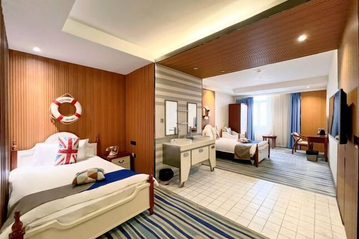 A hotel room with a bed, a desk, a chair, a television, and a bathroom.