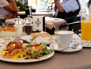A breakfast setting with plates of food, a coffee cup, and a glass of orange juice. - Nobildonne Relais (Rome)
