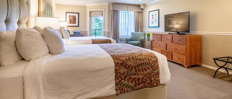 A hotel room with a large bed, a TV, a desk, and a chair.