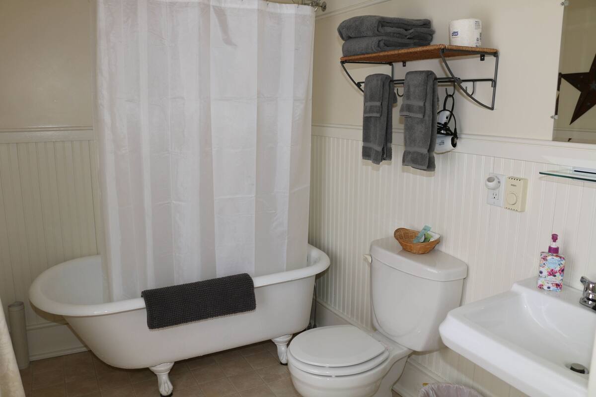A bathroom with a bathtub, toilet, and sink.