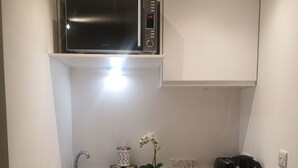 Una cocina compacta equipada con microondas, lavavajillas y tostadora.