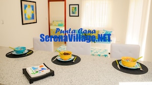 A dining area with a table set for breakfast, featuring bowls of cereal and a cake. - Serena Village (Punta Cana)