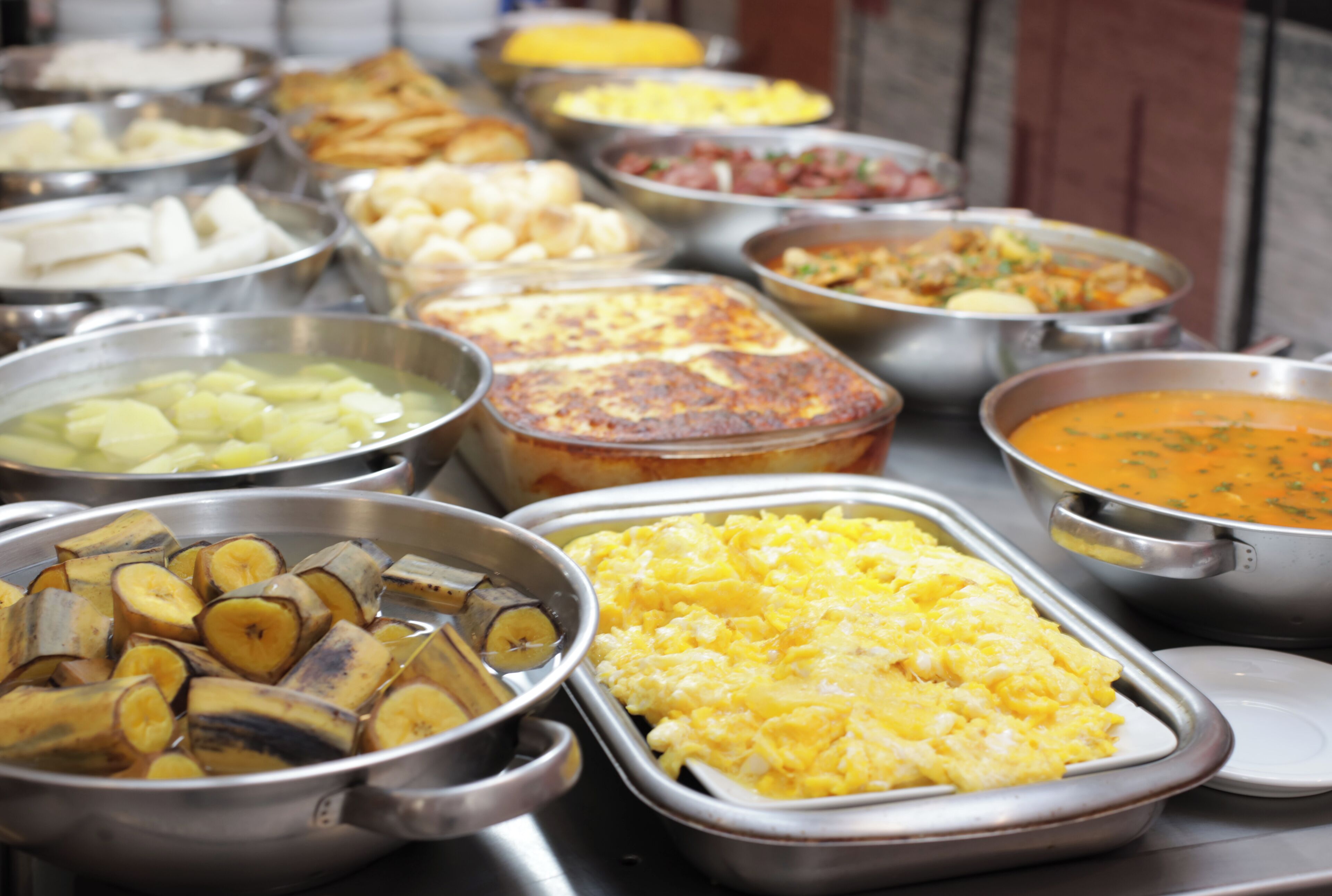 A buffet with various dishes including fruits, eggs, and a casserole.