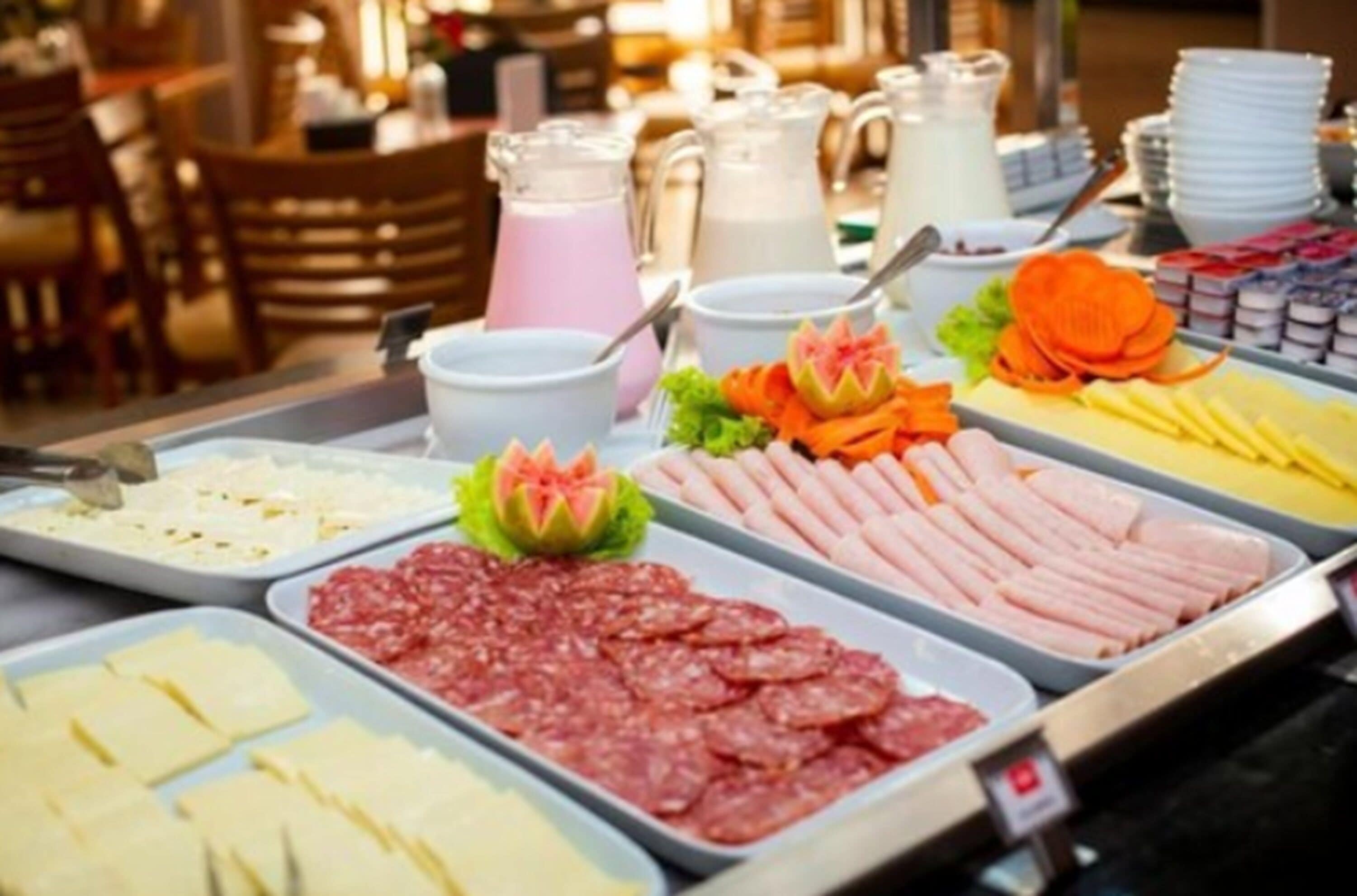 A buffet with various food items including meats, cheeses, and a beverage station.