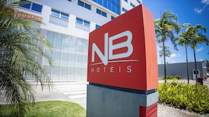 A hotel sign with 'NB HOTÉIS' and a modern building in the background. - NB Hotéis (Aracaju)