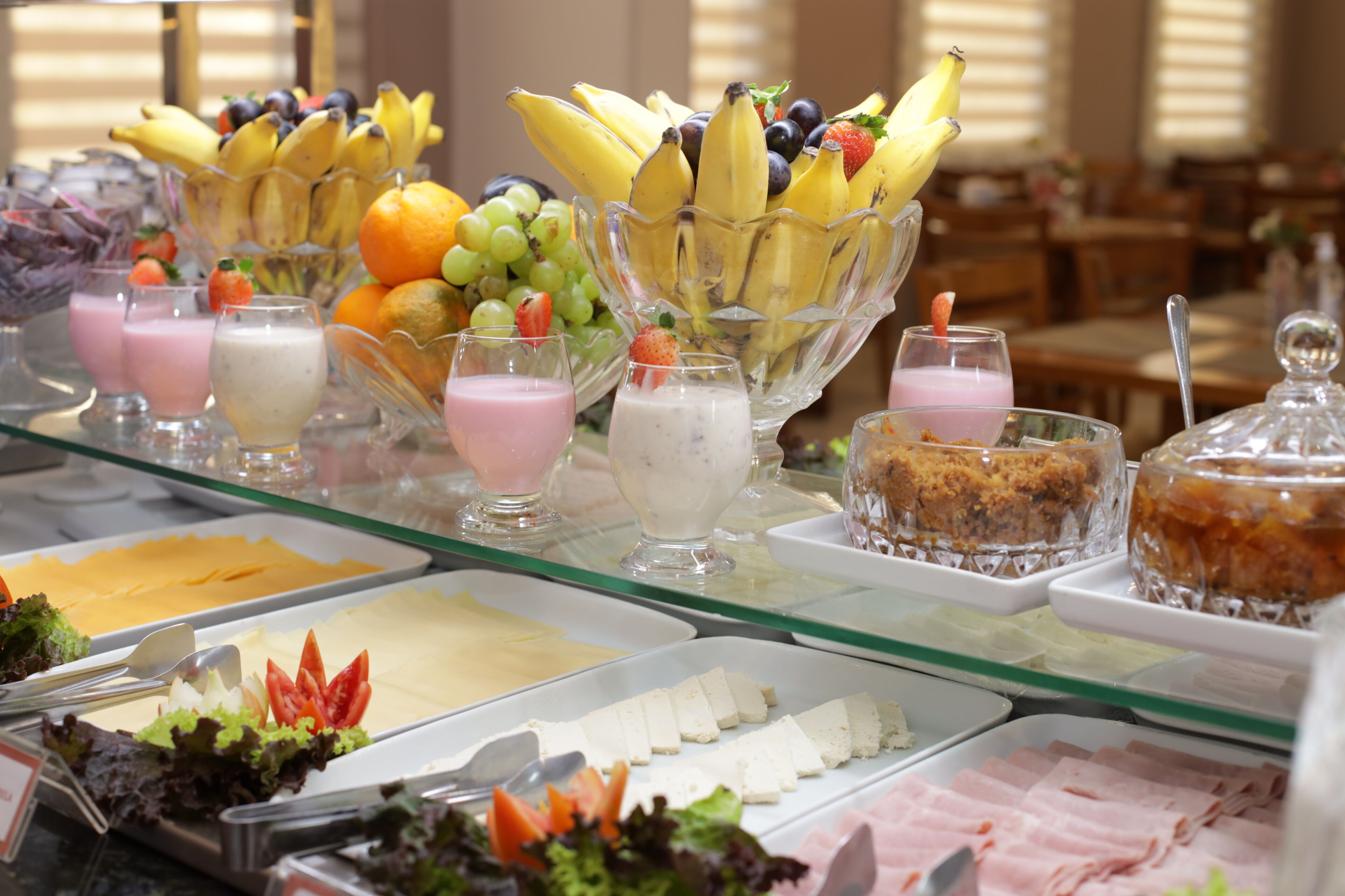 Un bufé con diversos alimentos, incluyendo frutas, lácteos y carnes.