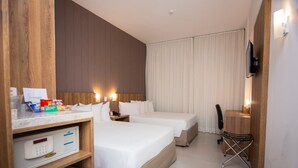 A hotel room with two beds, a desk, a chair, a TV, and a minibar. - NB Hotéis (Aracaju)