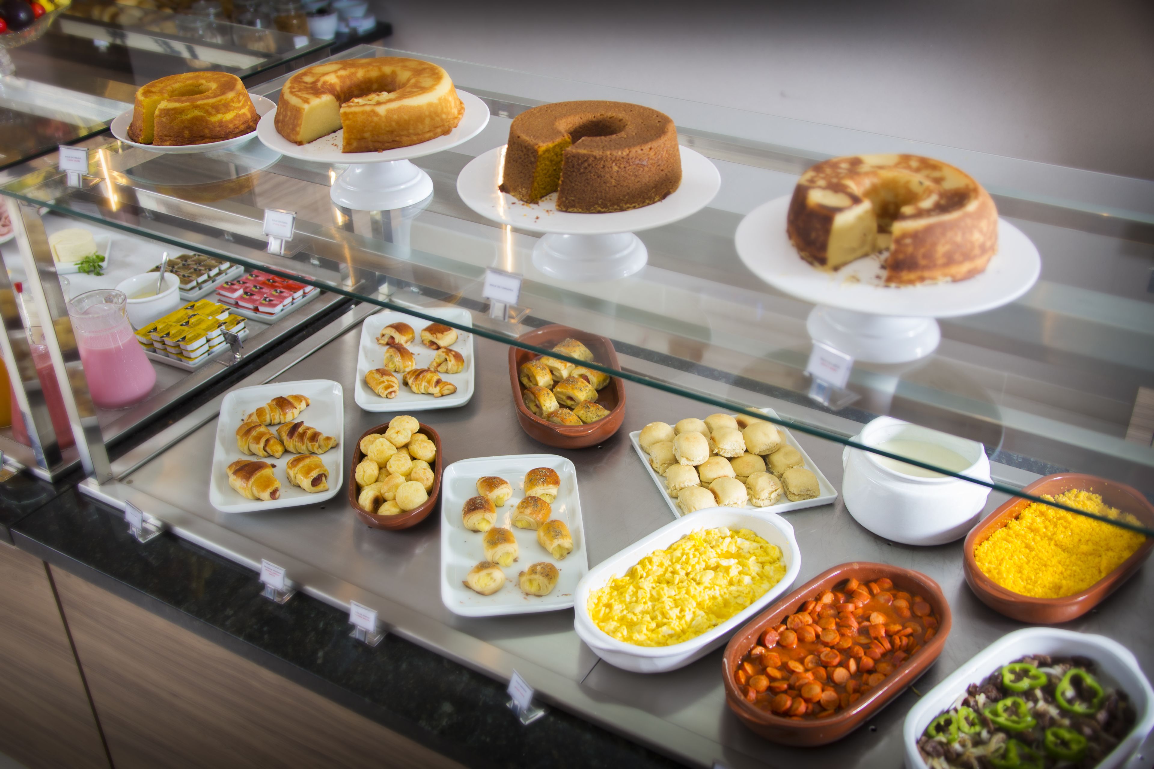 A buffet with various baked goods, pastries, and side dishes.