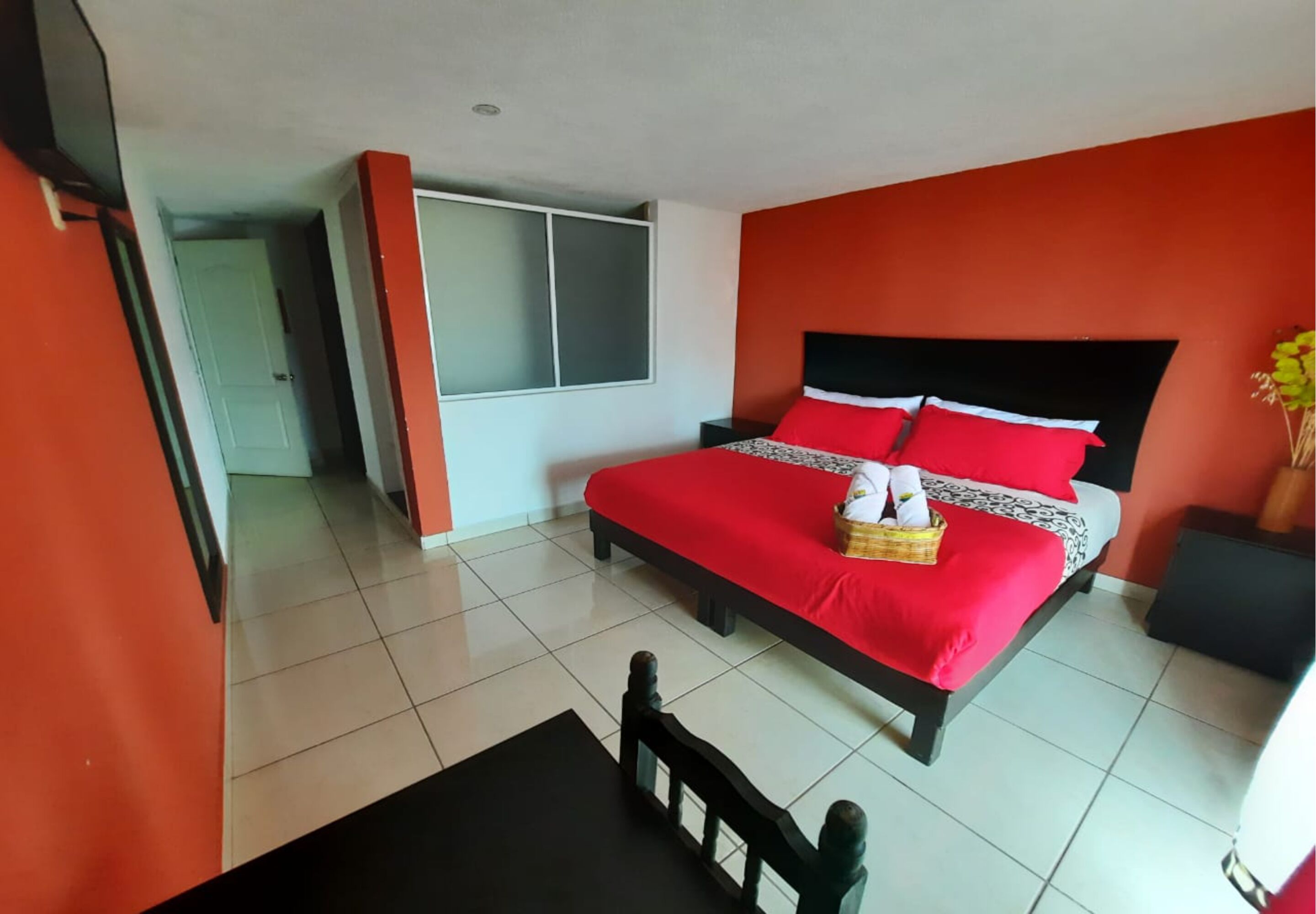 A hotel room with a bed, a small table, and a chair.