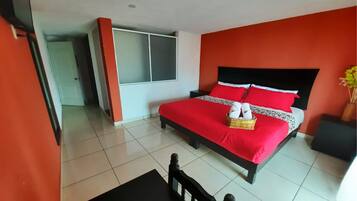 A hotel room with a bed, a small table, and a chair.